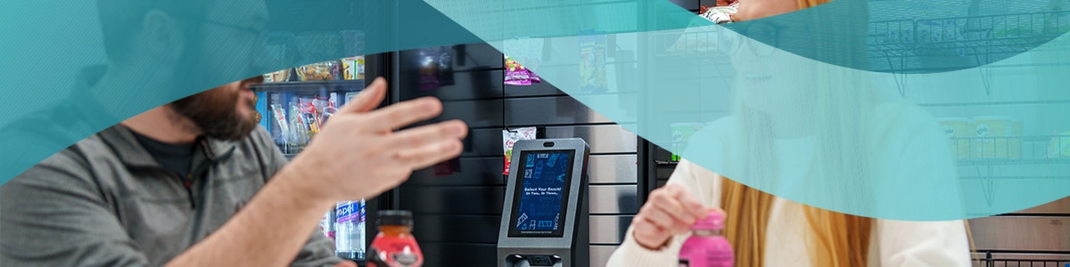 Two colleagues enjoying a snack together while chatting in front of a kiosk in a micro market